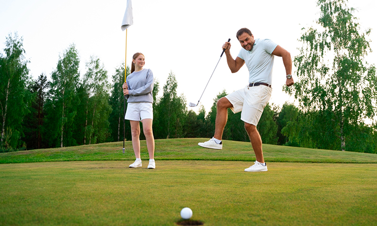 Golf instructor helping a student improve grip and stance during a golf lesson 